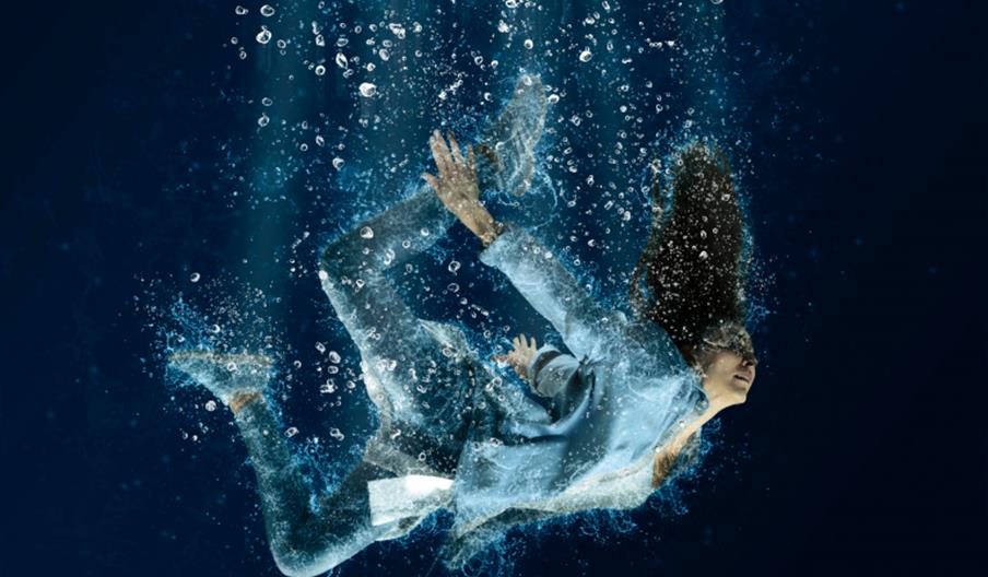 Picture of a lady clothed floating underwater