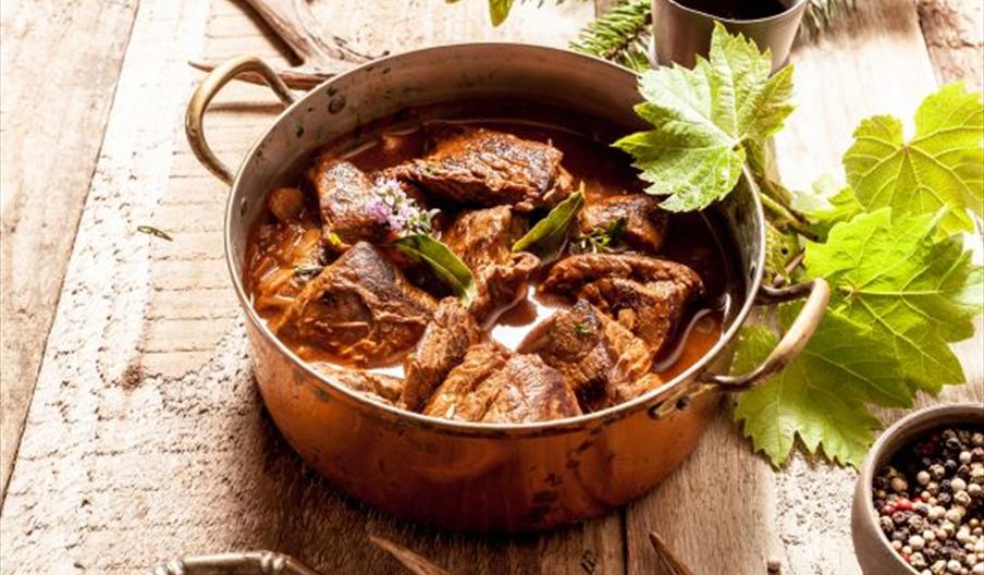 Image shows a delicious-looking game dish in a saucepan