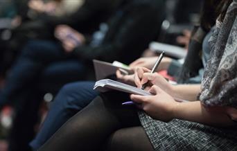 People taking notes at a lecture
