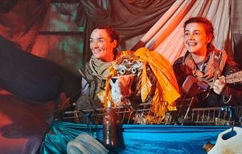 Two actors and a puppet in Stories in the Dust