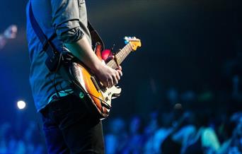 Guitarist playing to a large crowd