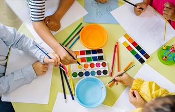 Children using pencils paint and colourful paint