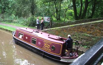 A narrow boat on the Caldon Canal passes below Turnover Bridge