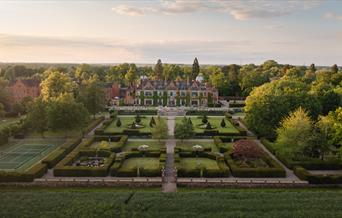 A drone shot of Hoar Cross Hall at sunrise, showing the perfectly manicured grounds and the beautiful surroundings