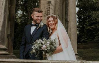 A bride and groom under an archway at The Trentham Estate