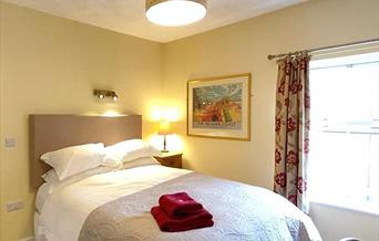 One of the bedrooms at The Victoria in Newcastle-under-Lyme, Staffordshire. Image shows the bed and furnishings.
