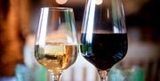A close up of two glasses of wine, one white, one red