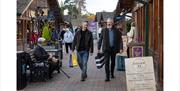 Two men walking through the Trentham Shopping Village.