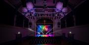 A light show underway inside a theatre auditorium, before guests arrive