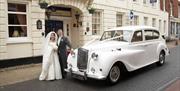 Classic Car with Bride and Groom outside the George Hotel.