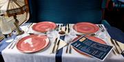 Places set, ready for diners to arrive, in a classic steam train carriage