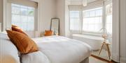 The Master Suite at Constantine House, with beautiful white and orange furnishings and a free-standing bath