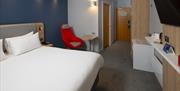 Image shows the entrance to the room and distance between the bed and other furniture