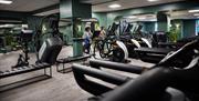 The well-equipped gym at Hoar Cross Hall, with a couple of guests pushing themselves on the exercise bikes