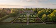 A drone shot of Hoar Cross Hall at sunrise, showing the perfectly manicured grounds and the beautiful surroundings