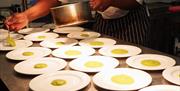 Image shows dishes being plated up in the kitchen at the Hammersley Restaurant, Stoke-on-Trent College