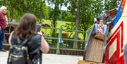 A mum, waiting at the bottom of the helter skelter, takes a picture of a young girl and her dad as they slide around the bend