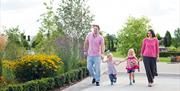 Family with young children walking in National Memorial Arboretum grounds, Staffordshire