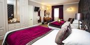 Image shows a family room at The Moat House, with two inviting double beds next to each other, classic wardrobes, and all mod cons