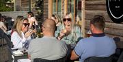 Friends enjoying a drink outside at one of the restaurants at Trentham Shopping Village.