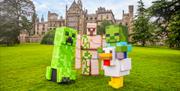 Large Minecraft character models displayed on the lawn of a historic estate.