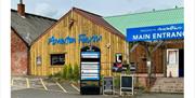Entrance to Amerton Farm with wooden buildings and main entrance signage.