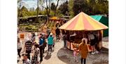 Families enjoying vintage fairground rides at Byrkley Park Garden Centre.