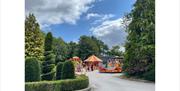 Mini vintage fun fair set among trees at Byrkley Park Garden Centre.