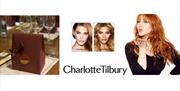 Charlotte Tilbury event branding with makeup look examples, a promotional image on a white background, and a small luxury gift bag placed on a table w