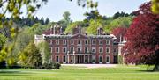 Image shows the House at Weston Park, seen from afar on a sunny day