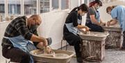 Visitors throwing a pot at World of Wedgwood Creative Studios