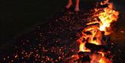 Glowing firewalk path with someone stepping toward the embers.