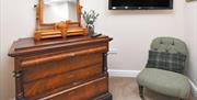 A chest of drawers, comfortable chair, and wall-mounted plasma screen at The Fountain Inn, Room 2