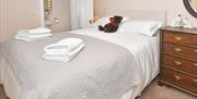 Room 3 at The Fountain Inn, with the bed and teddy bear ready for guests to arrive. You can also see into the bathroom.