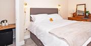 One of the spacious bedrooms with bed, fridge, tea & coffee making facilities, and desk/dressing table