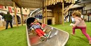 Kids at indoor slide in play barn