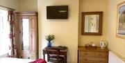 One of the bedrooms at The Victoria in Newcastle-under-Lyme, Staffordshire. Image shows the bed, plasma TV, tea and coffee making facilities, and furn