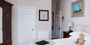One of the bedrooms, with bed, wardrobe, and items on the bed including towels, a leather folder and a teddy