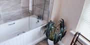 A bath/shower unit in one of the ensuite bathrooms